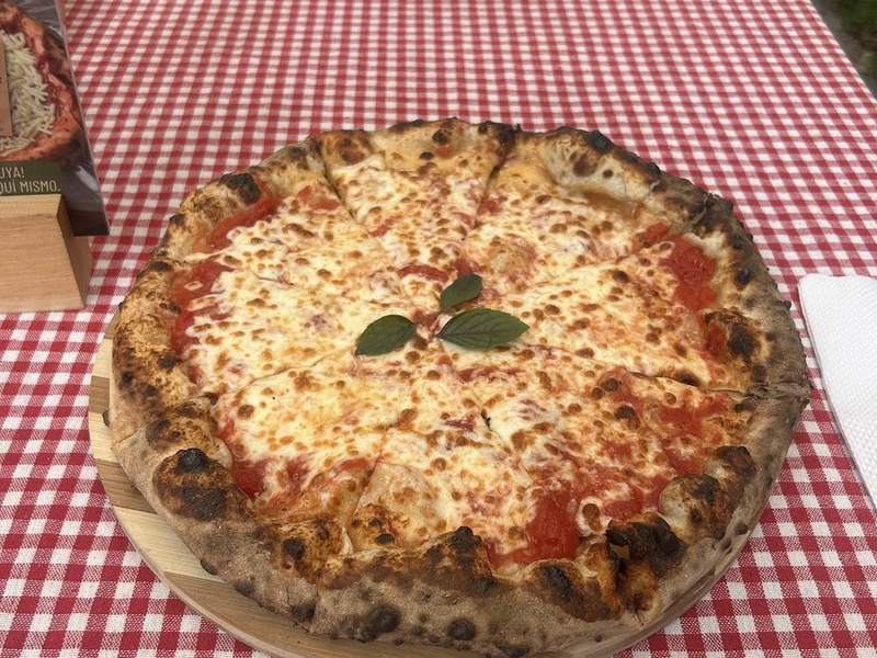 Pizza Margherita de Grazia sobre mantel a cuadros rojos
