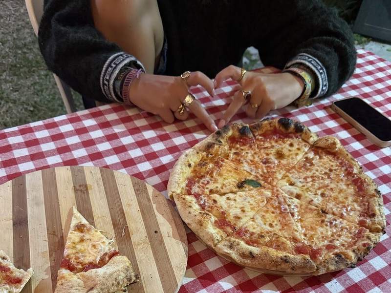 Clientes compartiendo una pizza de Grazia sobre mantel a cuadros